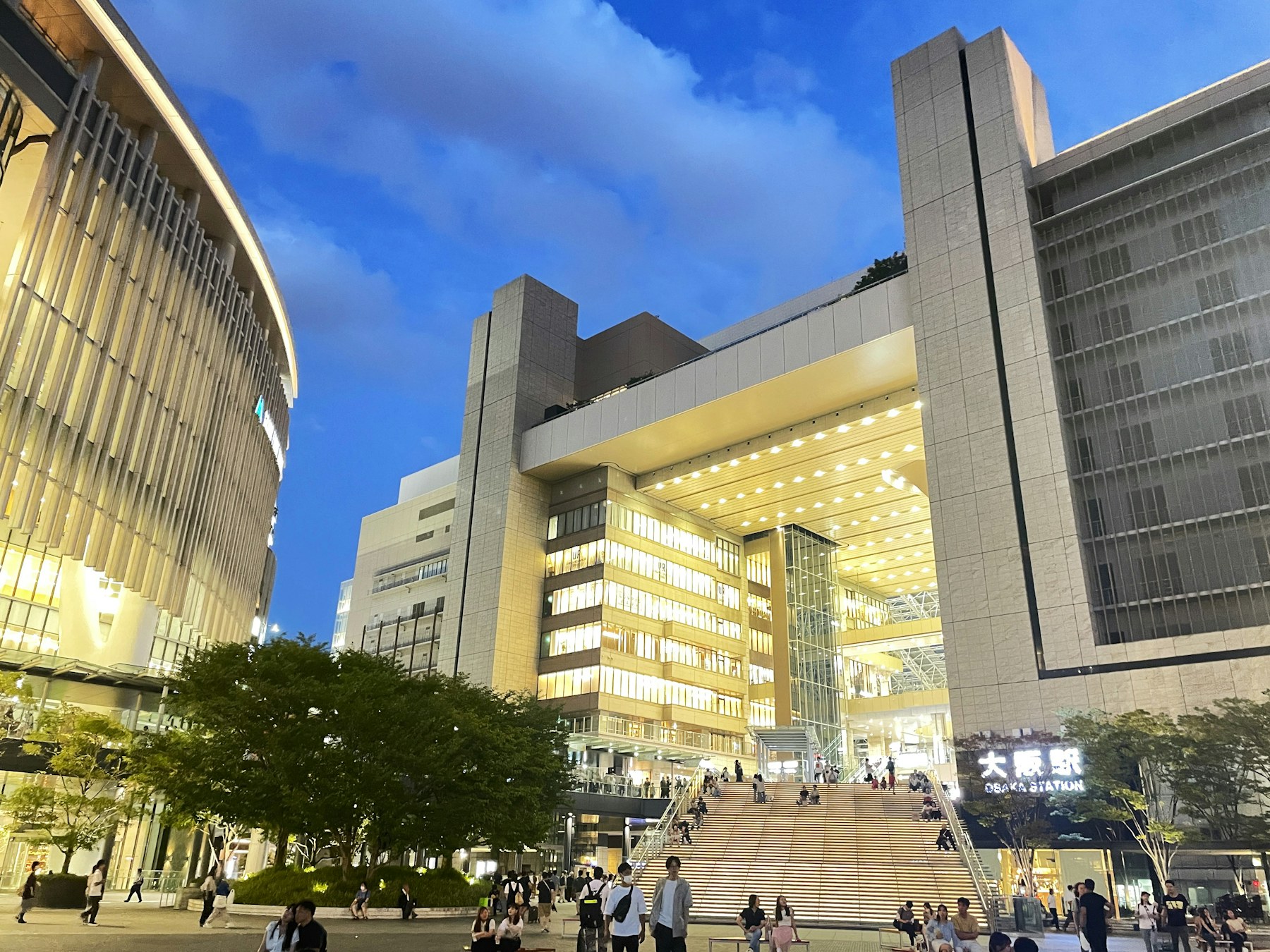 Pedestrians walking beside modern buildings near Osaka Station in Umeda