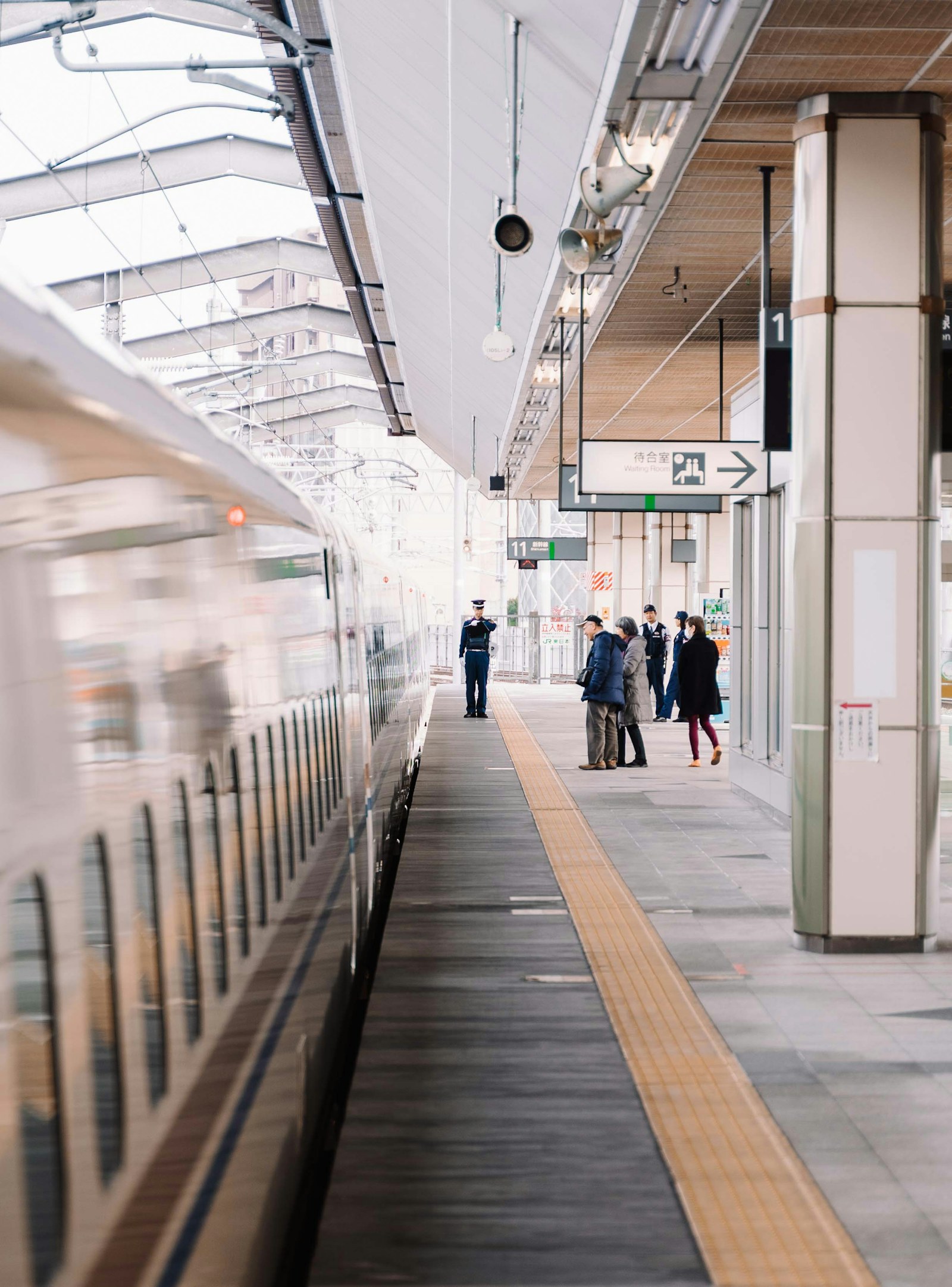 Travelers walking through a Japanese station after a Shinkansen arrival